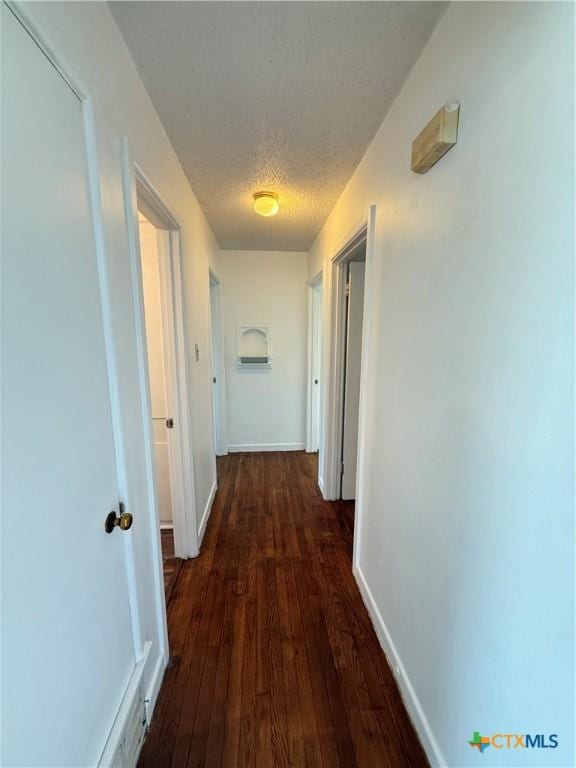 2310 Terrace Dr, Killeen, TX 76543 - hall featuring a textured ceiling, baseboards, and dark wood-style flooring