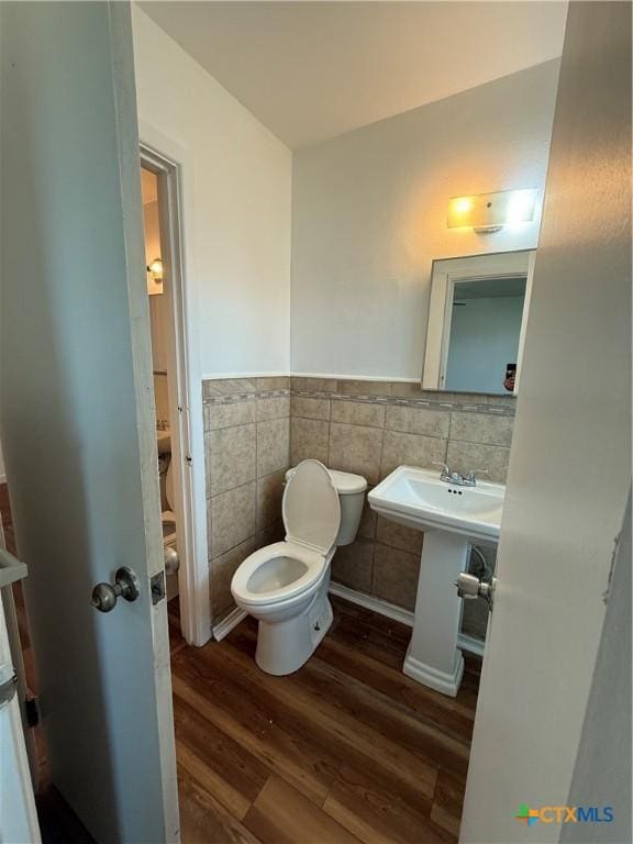 2310 Terrace Dr, Killeen, TX 76543 - half bath featuring a wainscoted wall, a sink, toilet, tile walls, and wood finished floors