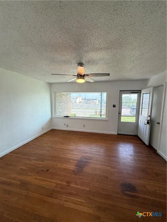 2310 Terrace Dr, Killeen, TX 76543 - interior space featuring a textured ceiling, a ceiling fan, baseboards, and dark wood-style flooring