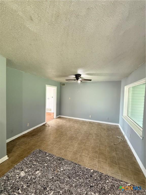 2310 Terrace Dr, Killeen, TX 76543 - empty room with tile patterned floors, visible vents, baseboards, a textured ceiling, and ceiling fan