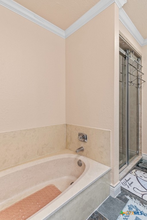 bathroom featuring a textured ceiling, a bathing tub, and ornamental molding