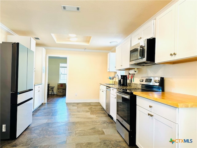 kitchen with white cabinetry, stainless steel appliances, sink, and crown molding