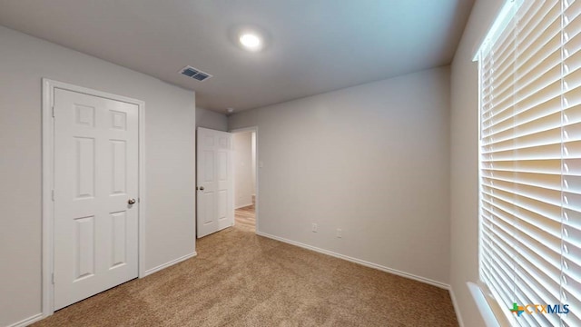 unfurnished bedroom featuring light colored carpet