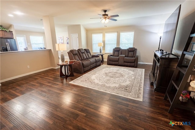 living room with dark hardwood / wood-style floors, a wealth of natural light, and ceiling fan