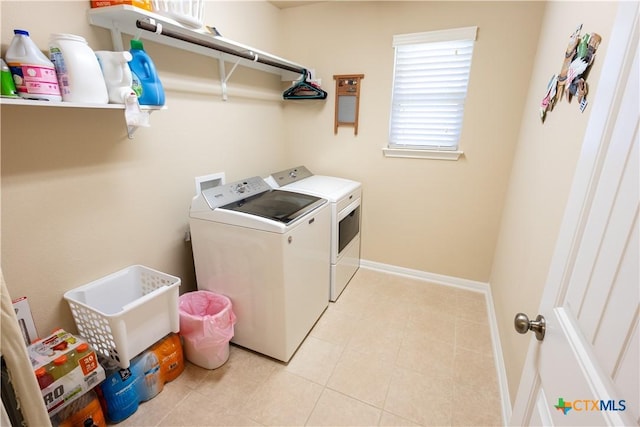 washroom with light tile patterned floors and washing machine and clothes dryer