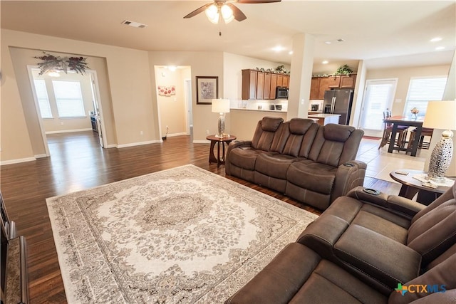 living room featuring ceiling fan and dark wood-type flooring