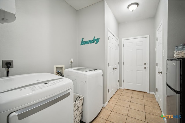 washroom featuring washing machine and clothes dryer and light tile patterned floors