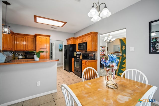 kitchen featuring black appliances, a notable chandelier, light tile patterned floors, pendant lighting, and decorative backsplash