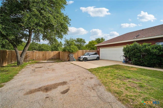 view of side of home featuring a garage and a yard