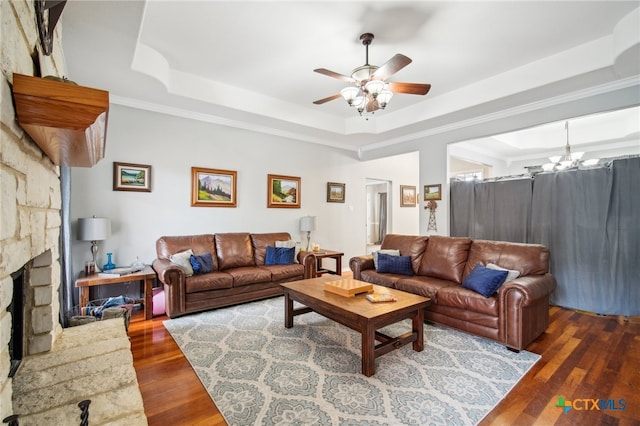 living room featuring dark hardwood / wood-style flooring, a tray ceiling, and ornamental molding