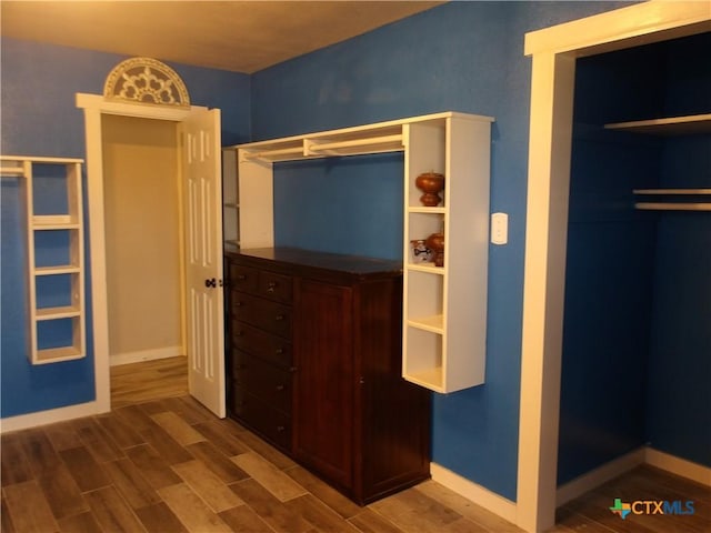 unfurnished bedroom featuring baseboards and wood finish floors