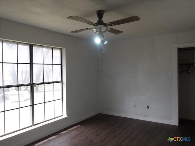 unfurnished room with ceiling fan, baseboards, and dark wood-style flooring