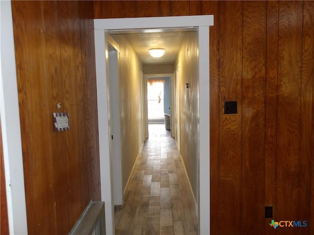 hallway featuring wood finished floors and baseboards