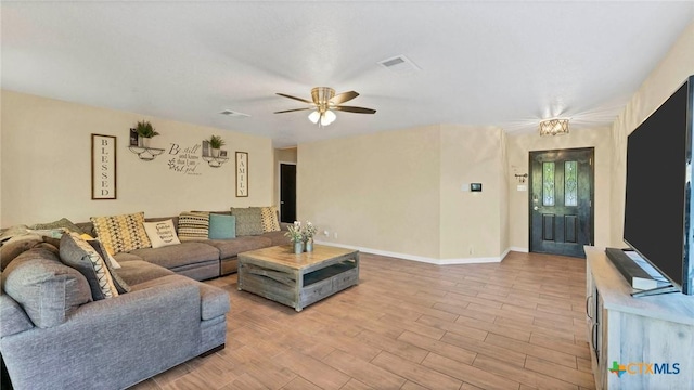 living room featuring ceiling fan, light wood-style flooring, and baseboards