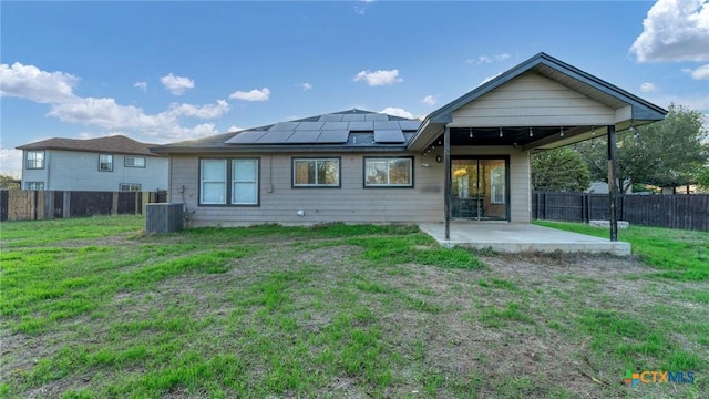 back of property with a patio area, solar panels, and central AC