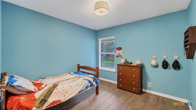 bedroom with wood finished floors and baseboards