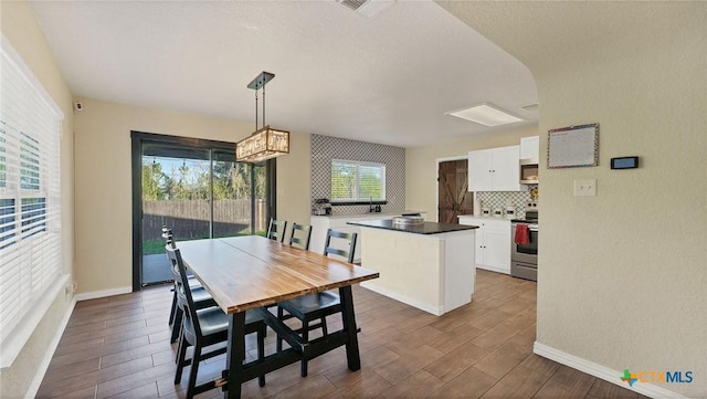 dining area featuring dark wood-type flooring and baseboards