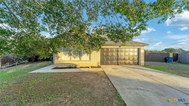view of front of home featuring brick siding, driveway, a garage, and fence