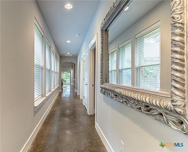 1002 Merry Ln, Kingsland, TX 78639 - hallway featuring arched walkways, recessed lighting, finished concrete floors, and a textured wall