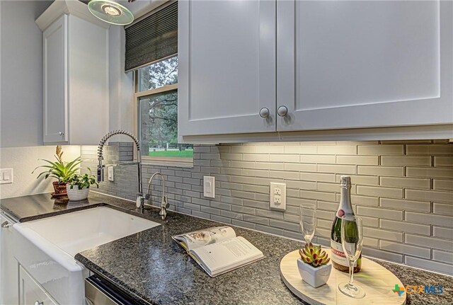 1002 Merry Ln, Kingsland, TX 78639 - kitchen with backsplash, dark stone counters, and white cabinetry