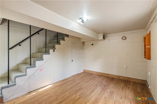 basement with wood-type flooring and a textured ceiling