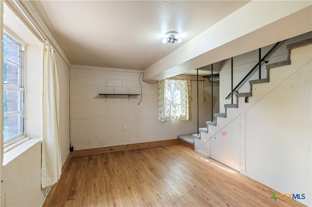 basement with hardwood / wood-style floors and a textured ceiling