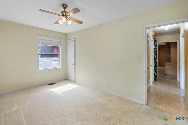 carpeted empty room with ornamental molding and ceiling fan