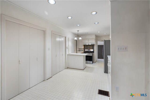 kitchen featuring light tile patterned flooring, white cabinetry, appliances with stainless steel finishes, tasteful backsplash, and hanging light fixtures