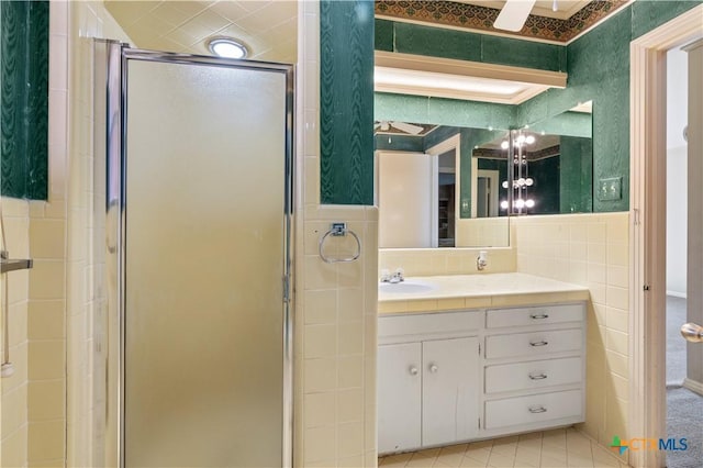 701 Live Oak St, Gatesville, TX 76528 - bathroom with tile walls, a shower stall, vanity, and tile patterned flooring