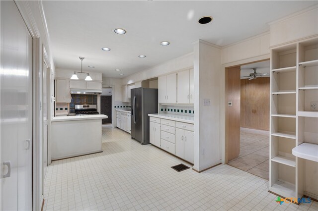 kitchen with hanging light fixtures, white cabinetry, decorative backsplash, and appliances with stainless steel finishes