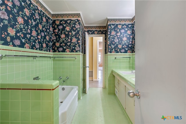 bathroom with vanity, tile walls, ornamental molding, and a bathing tub