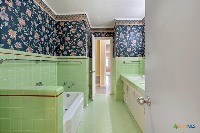701 Live Oak St, Gatesville, TX 76528 - full bath with wallpapered walls, crown molding, tile walls, wainscoting, and a garden tub