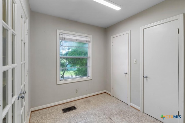 701 Live Oak St, Gatesville, TX 76528 - unfurnished bedroom featuring baseboards and french doors
