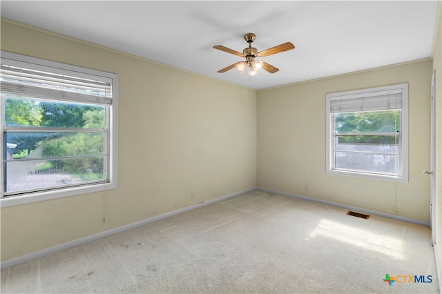 unfurnished room featuring ornamental molding, light carpet, and ceiling fan