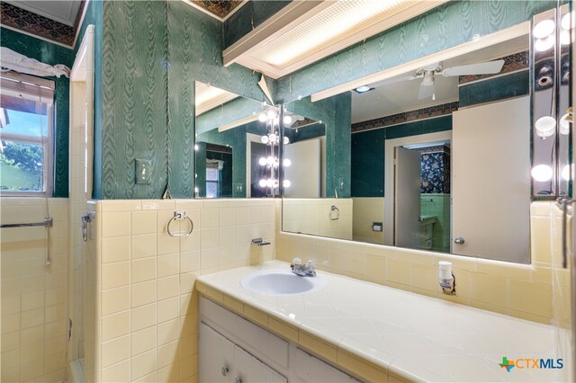 bathroom with tile walls, vanity, and a shower with shower door