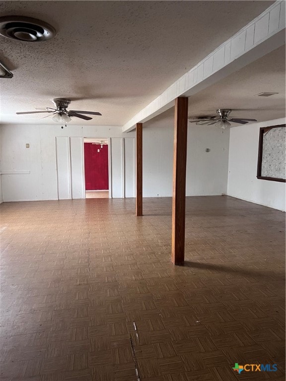 basement featuring dark parquet floors and a textured ceiling