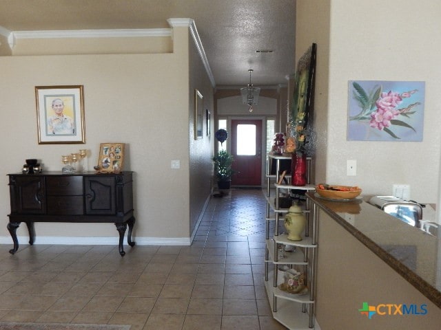 foyer featuring tile patterned flooring, a textured ceiling, and crown molding