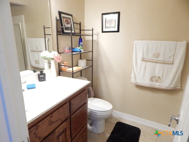 bathroom with toilet, an enclosed shower, vanity, and tile patterned floors