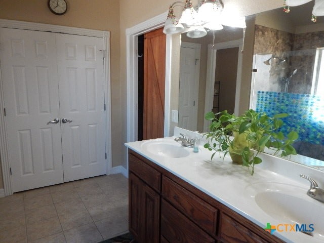 bathroom featuring walk in shower, a chandelier, vanity, and tile patterned floors