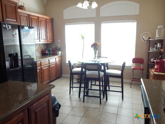 tiled dining area with an inviting chandelier