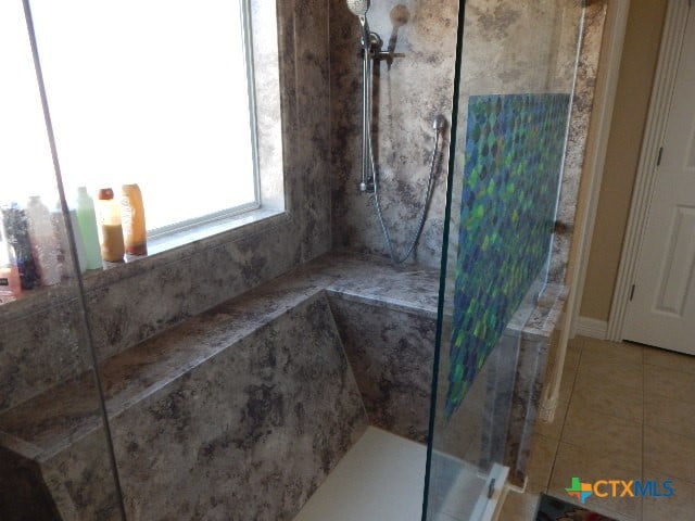 bathroom featuring tile patterned floors and a shower with shower door