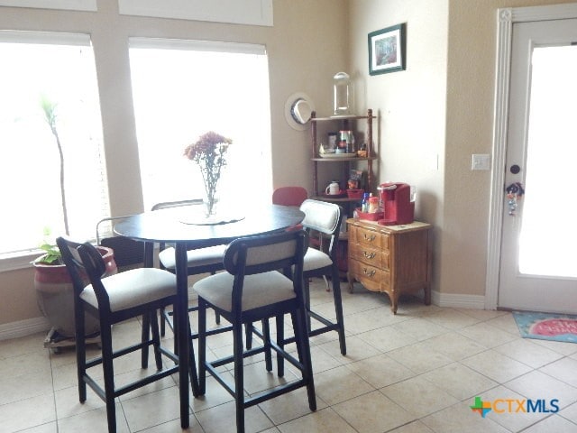 dining area with plenty of natural light and light tile patterned flooring