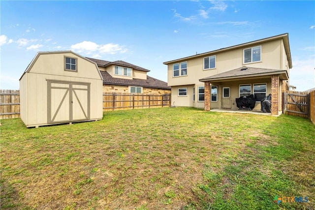 rear view of house with a patio area, a fenced backyard, a yard, and a storage shed