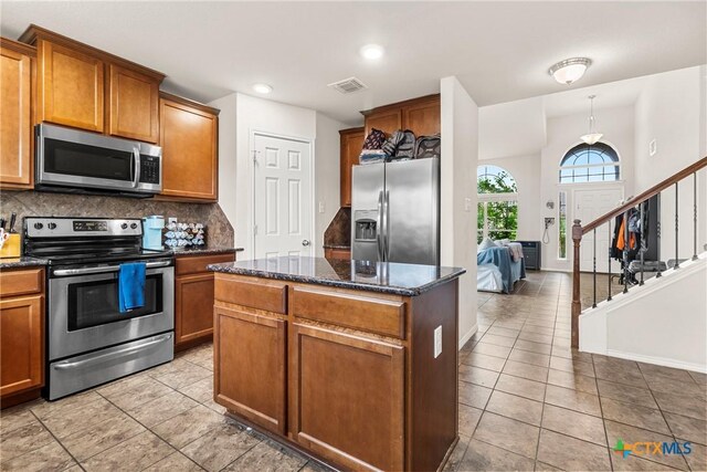 kitchen featuring light tile patterned floors, visible vents, stainless steel appliances, and a center island