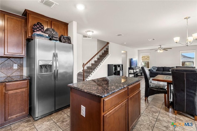 kitchen with tasteful backsplash, visible vents, a kitchen island, open floor plan, and stainless steel fridge with ice dispenser