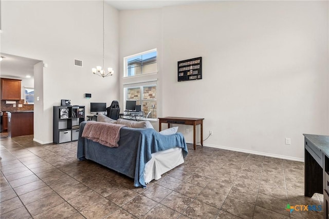 living room featuring a towering ceiling, visible vents, a chandelier, and baseboards