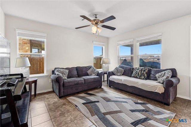 living room with a ceiling fan and baseboards