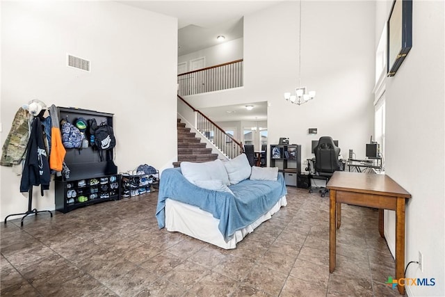 living room featuring visible vents, a notable chandelier, a high ceiling, and stairway