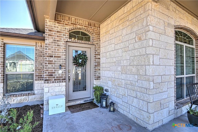 entrance to property with roof with shingles