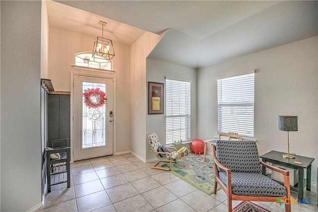 foyer entrance with light tile patterned floors and baseboards